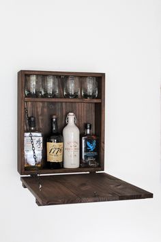 a wooden shelf with bottles and glasses on it