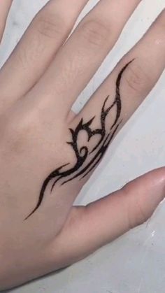 a person's hand with a tattoo on it and a ring in the middle