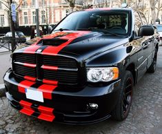 a black and red truck parked on the street