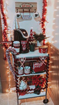 a christmas display in the corner of a room with lights and decorations on it's shelves