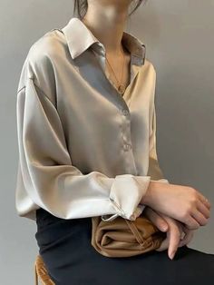 Elegant Silk White Blouse - Classic Long Sleeve Shirt for Women Discover timeless elegance with this luxurious silk white blouse. Featuring a classic design with a relaxed fit, this long sleeve shirt is perfect for both professional and casual settings. The soft, silky fabric drapes beautifully, offering comfort and style in one. Pair it with tailored trousers for a sophisticated office look or with jeans for a chic, effortless outfit. Versatile and stylish, this blouse is a must-have addition t Cream Satin Shirt Outfit, Satin Button Down Shirt Outfit Work, Stylish T Shirts For Women, White Shirt Formal Outfit Women, Long Sleeves Outfit Casual, Silk Button Down Shirt Outfit, Formal Shirts Women, Satin Shirts For Women, Satin Shirt Outfit