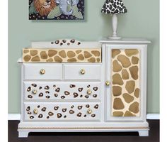 a giraffe print dresser with two lamps on the top and an animal painting above it