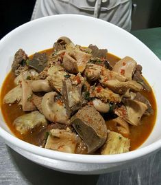 a white bowl filled with food on top of a table