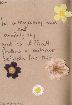 a piece of brown paper with flowers and words written on the bottom, in front of it