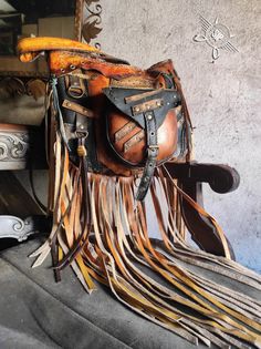 Unique and stunning crossbody leather bag with fringes, featuring a long adjustable strap, inspired by steampunk, post-apocalyptic, and boho styles. The bag comes in a orange-brown color with black and red accents, resembling blood splatters. It boasts numerous details such as rivets, leather rings, straps, laces, and canvas inserts. Ideal for tall individuals. Multiple pockets both inside and outside, with a strong lining. Semi-circular shape with rugged, distressed edges. High-quality craftsma Leather Rings, Crossbody Leather Bag, Leather Fringe Bag, Leather Ring, Fringe Bags, Brown Leather Bag, Leather Conditioner, Leather Bags Handmade, Leather Hobo Bag