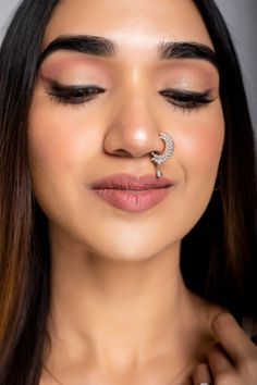 a woman with her nose piercing in the shape of a crescent on top of her nose