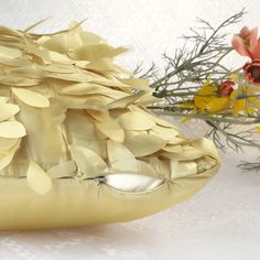 a close up of a vase with flowers in it on a white tableclothed surface