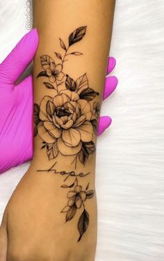 a woman's arm with a flower tattoo on it