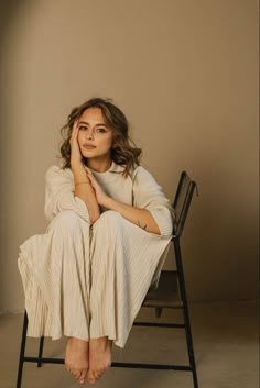 a woman sitting in a chair with her legs crossed