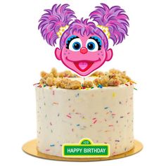 a birthday cake with an image of a pink troll head on top and sprinkles around it