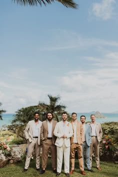 a group of men standing next to each other on top of a lush green field