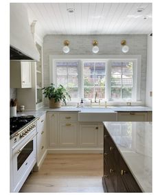 a kitchen with white cabinets and marble counter tops