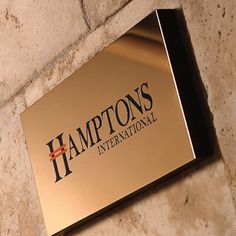 a sign on the side of a building that says hampton's international in black and gold