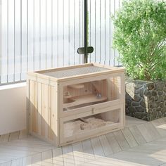 a small wooden box sitting on top of a hard wood floor next to a tree