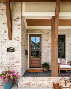 the front porch is decorated with flowers and plants