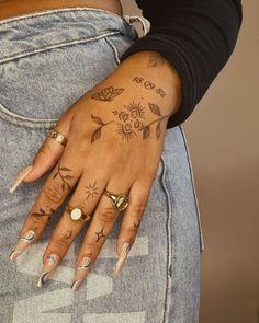 a woman's hand with tattoos on her left arm and two rings on her left wrist