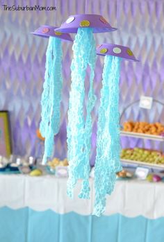 a table topped with lots of food under a purple sky light hanging from it's ceiling