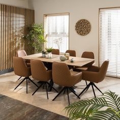 a dining room table surrounded by brown chairs