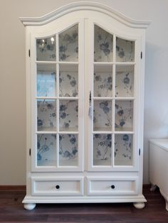 a white china cabinet with flowers on it