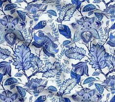 a blue and white floral print fabric with large leaves on the bottom half of it