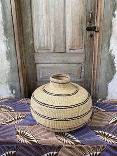 a basket sitting on top of a rug next to a door with a wooden handle