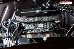 the engine compartment of an old car with chrome trim and black paint on it's hood