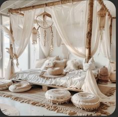 a canopy bed with white sheets and pillows