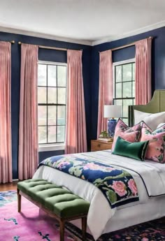 a bedroom with blue walls, pink and green curtains, white bedding, and an upholstered bench in front of the window