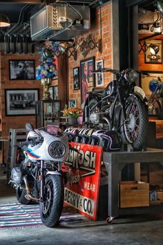 a motorcycle parked next to a red sign in a room with pictures on the wall