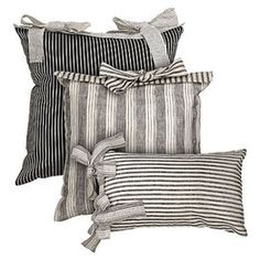 three black and white striped pillows with bows on the front, one is tied up