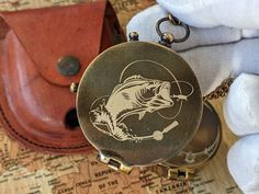 a close up of a pocket watch on a table with other items in the background