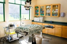 a hospital room with lots of medical equipment on the floor and in front of large windows