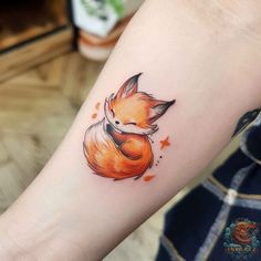 a small fox tattoo on the arm