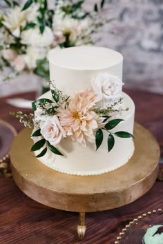 a white wedding cake with pink flowers and greenery