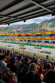 a crowd of people sitting in front of a race track