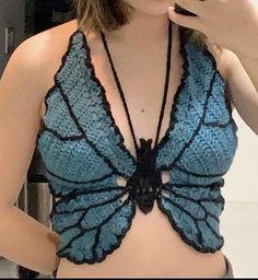 a woman in a blue butterfly bra top brushing her teeth