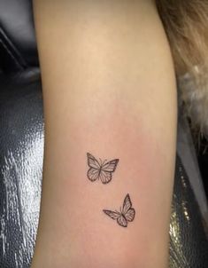 two butterflies tattoo on the left side of the leg, one is black and white