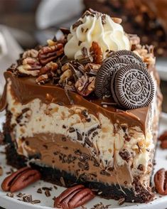 a piece of chocolate cheesecake on a plate with pecans and oreo cookies