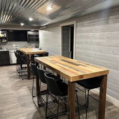 a kitchen area with bar stools and wooden table in front of the counter top