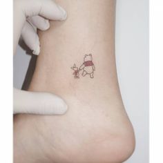 a person with a small tattoo on their foot that has a pooh bear on it