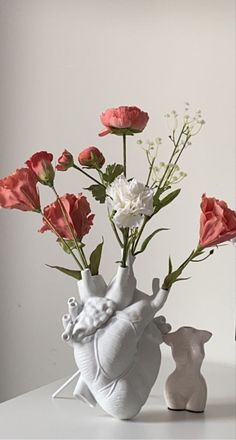 there is a vase with flowers in it and an elephant figurine next to it