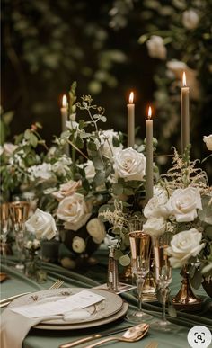 the table is set with candles, flowers and place settings for an elegant dinner party