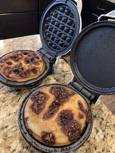 two waffles sitting on top of a counter next to an open panini maker