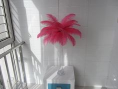 a pink feathered palm tree in a white tiled room with blue and gray accents