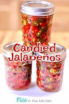 three jars filled with red and gold confetti sitting on top of a table