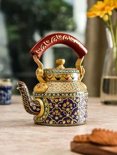 an ornate tea kettle sitting on top of a table