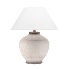 a white lamp sitting on top of a table next to a white light shade over it