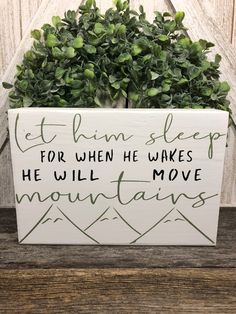 a wooden sign that says let him sleep for when he wakes, he will move mountains