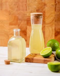 limes and a bottle of lemonade sit on a table