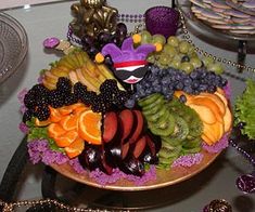 a platter filled with lots of different types of fruits and veggies on top of a table